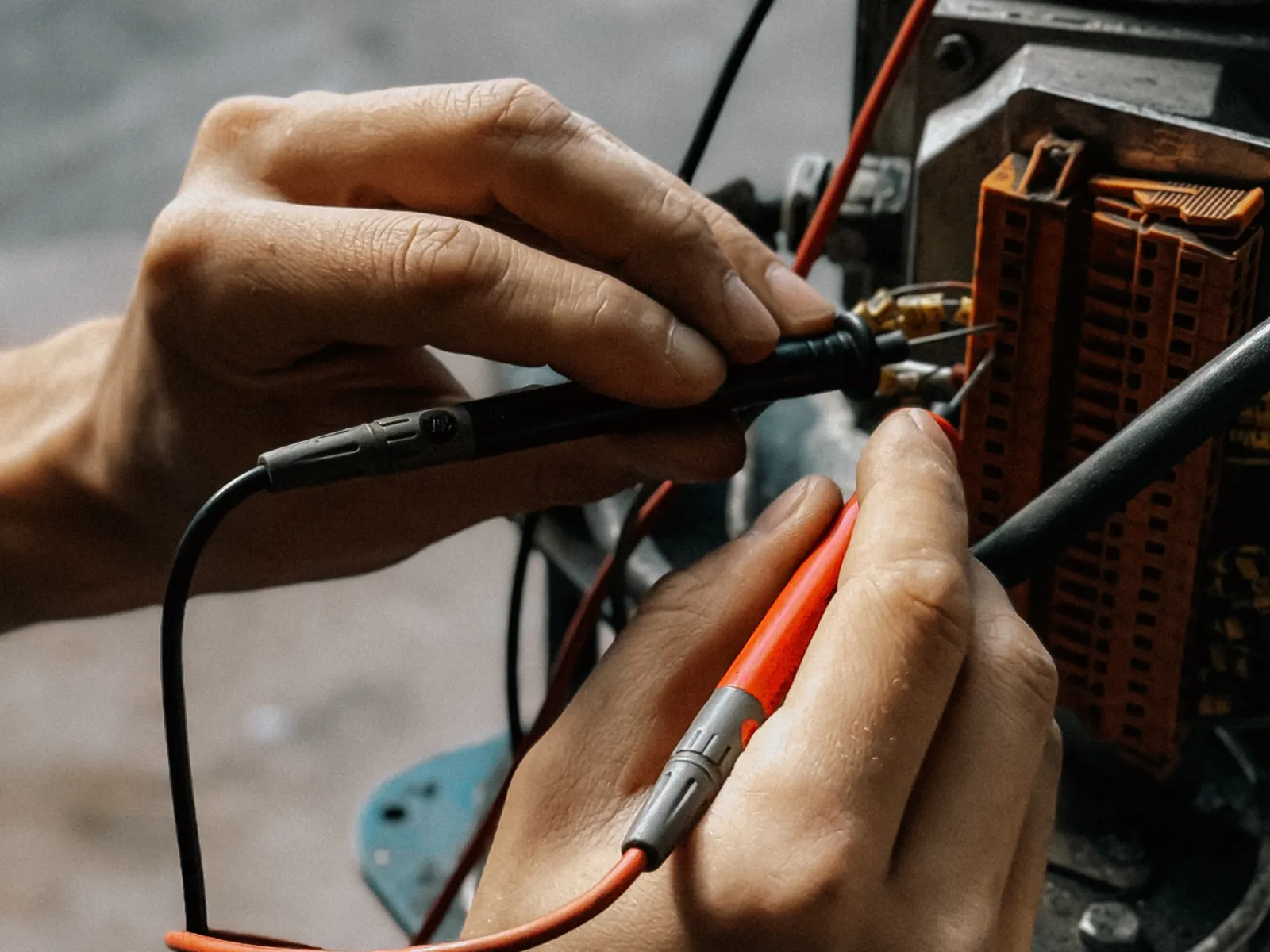 Técnico midiendo con puntas de prueba sobre la bornera de un equipo eléctrico